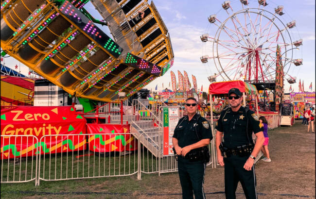 Sheriffs in front of a county fair ride