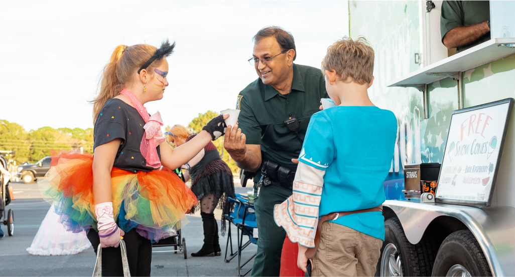 Sheriff giving snow cones to children