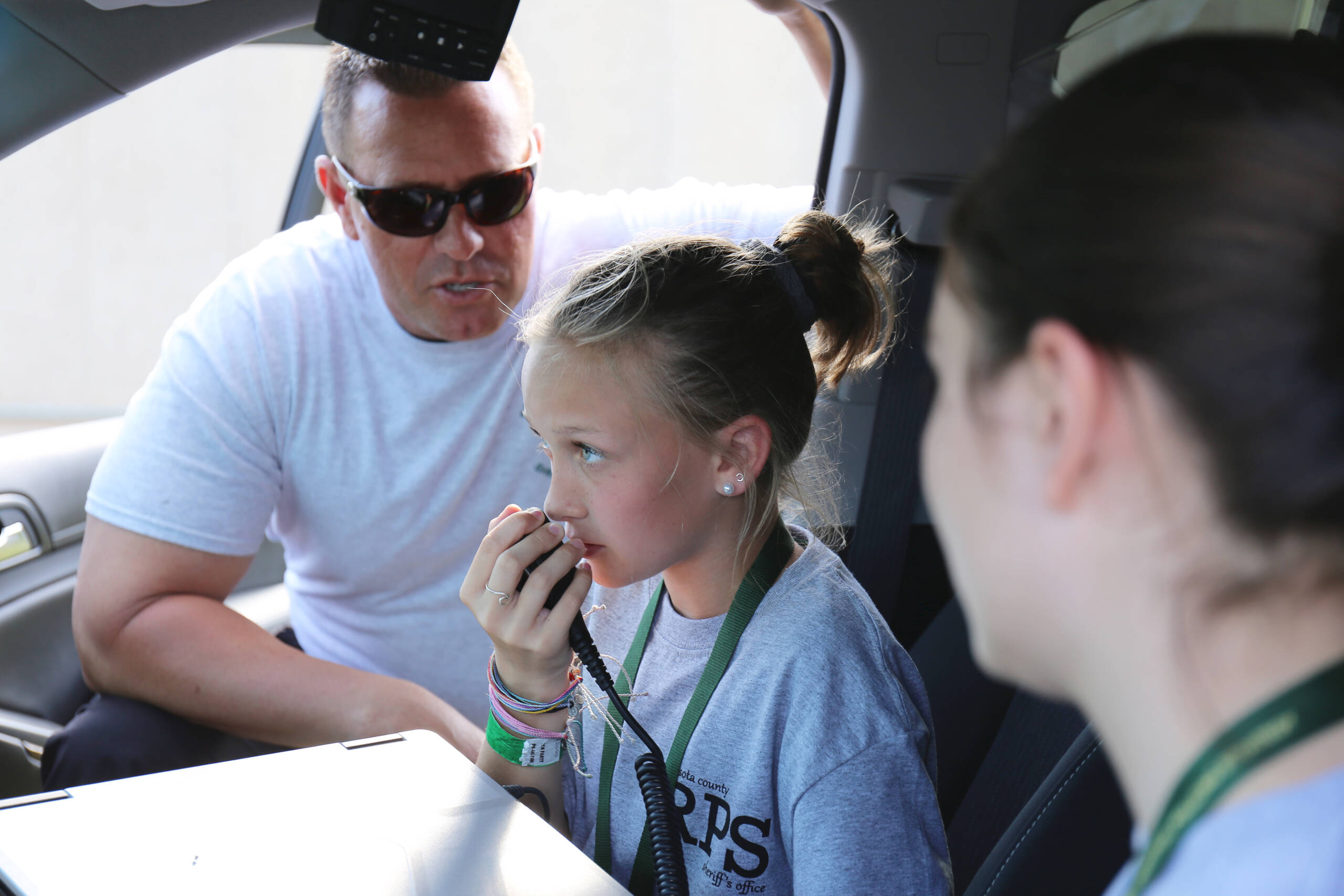 Student using walkie talkie with sheriff