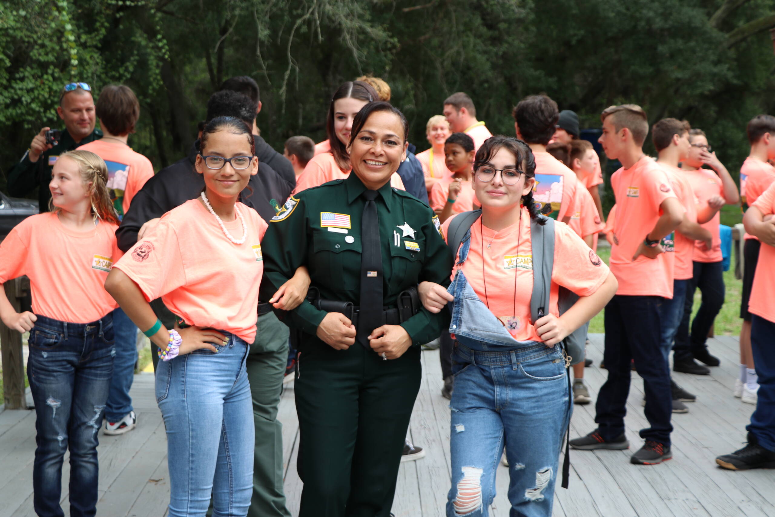 Officer standing with two girls amongst students