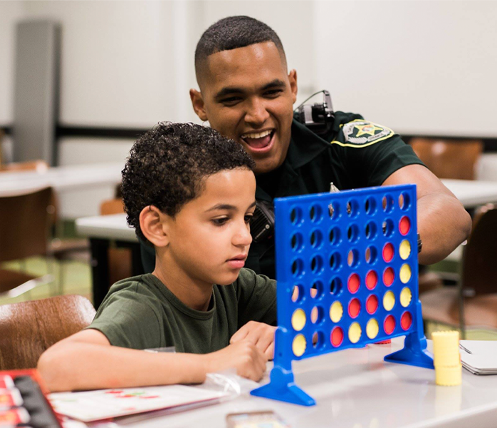 Officer playing connect 4 with child